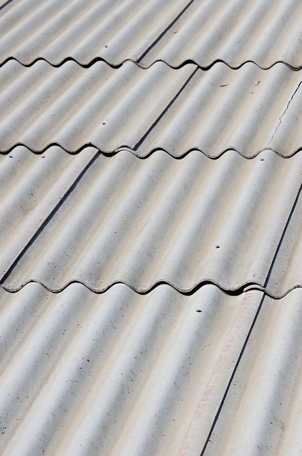 A fragment of a gray slate roof of an old sample made of asbesto